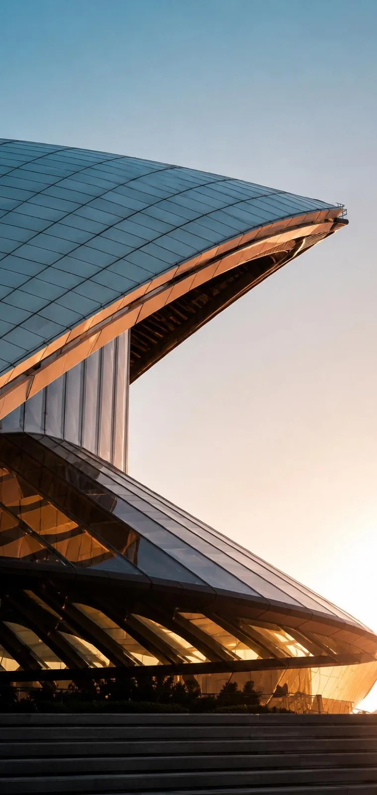 Curved timber-clad building at sunset
